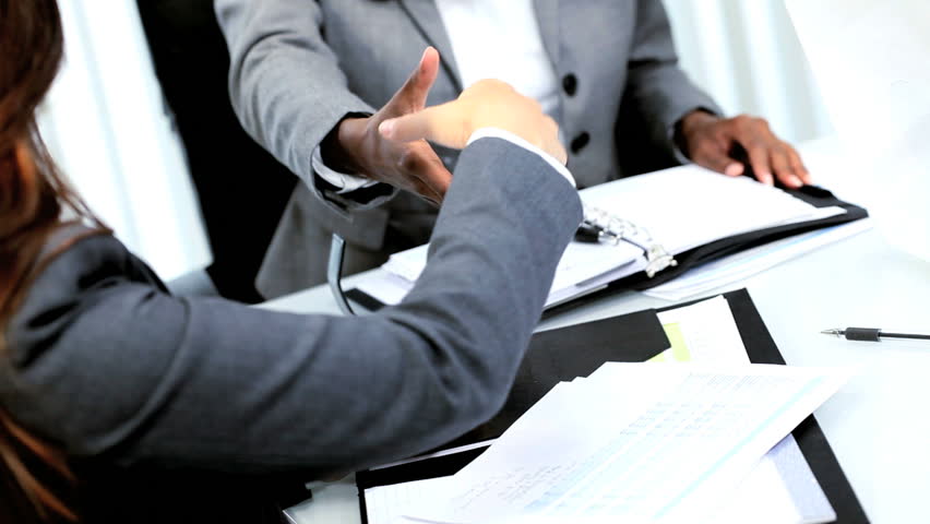 Handshake of ethnic female business manager closing deal with colleagues