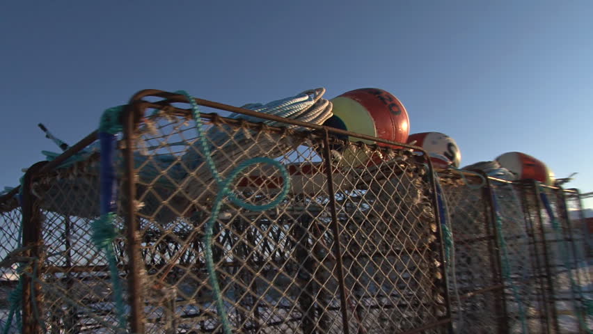 Steadicam (Glidecam) shot of passing by a stack of crab pots on the dock.