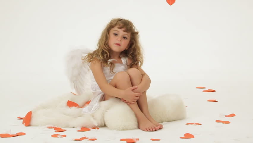 Little girl dressed as angel posing for camera.
