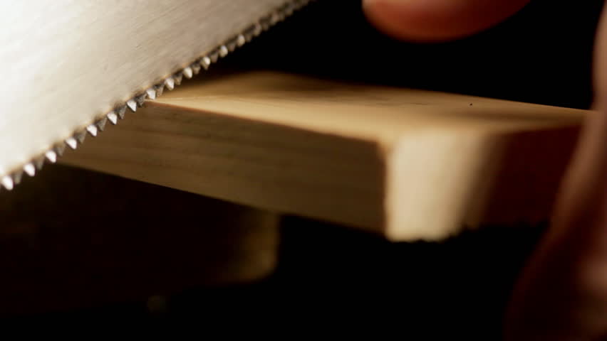 Carpenter sawing wooden plank CU