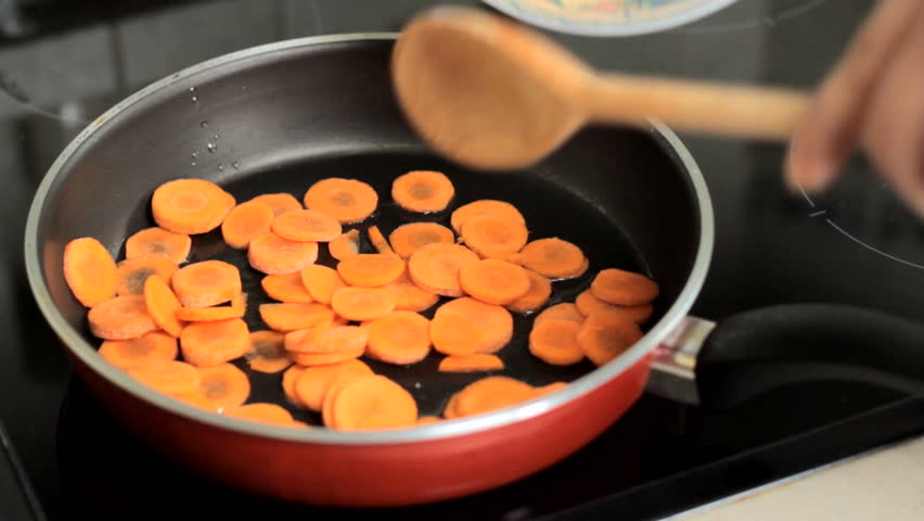 Throwing carrots into a frying pan