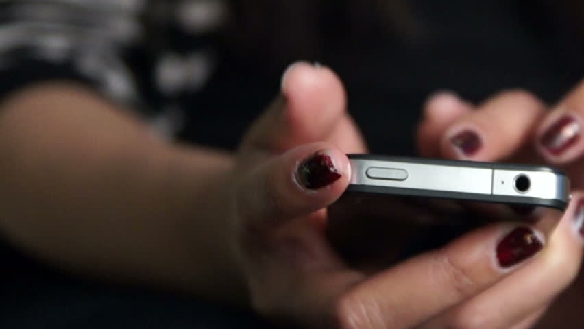Dolly shot of a teen using her iPhone