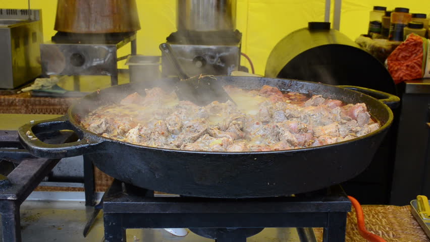 meat cook in pan on fire and vapour rise in outdoor restaurant.
