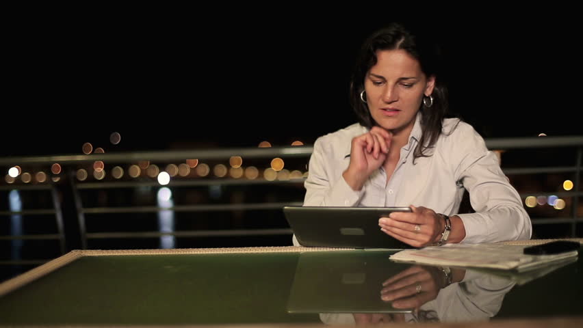 Businesswoman working with tablet and documents on terrace, crane shot
