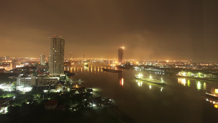 Night timelapse of the RIver of Kings, Chao Phraya River Bangkok. The river's ebb and tide are beautiful displayed with river plants going up and down.