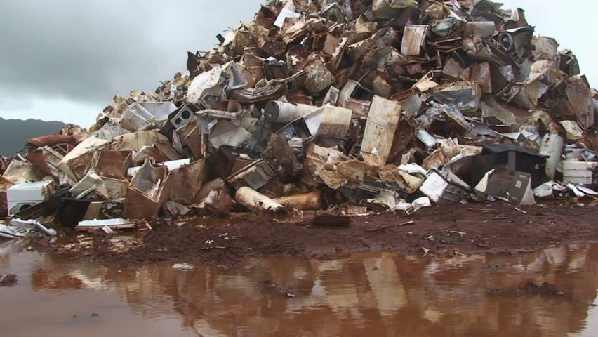 Metal scrap heap reflected in  muddy stagnant water