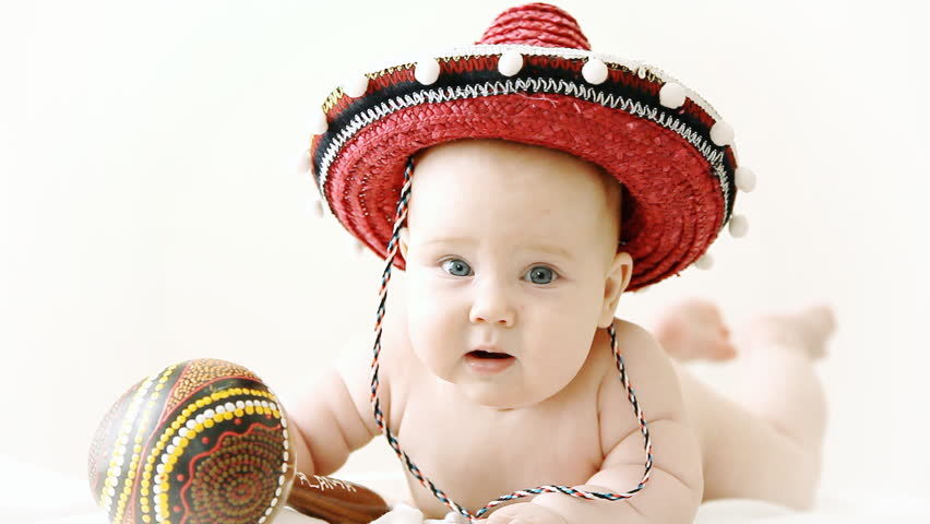 Baby in sombrero hat with maracas on the light background