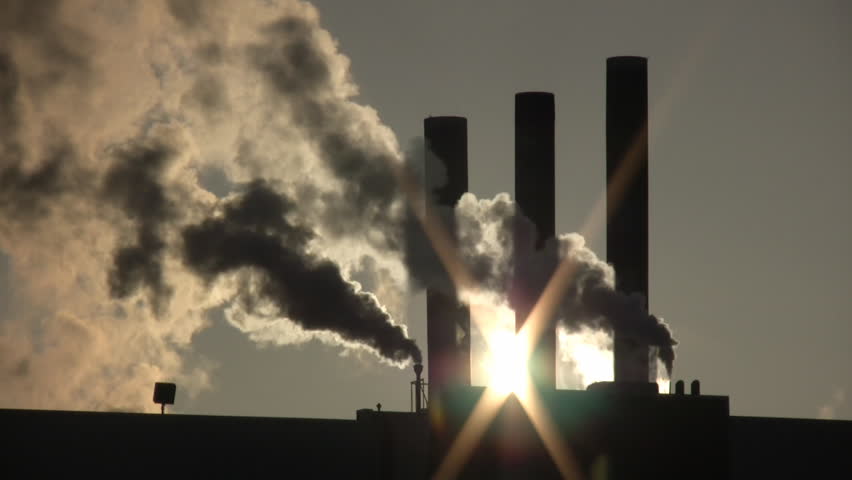 Fumes billow out of a giant smoke stack against the sunny sky (High Definition)