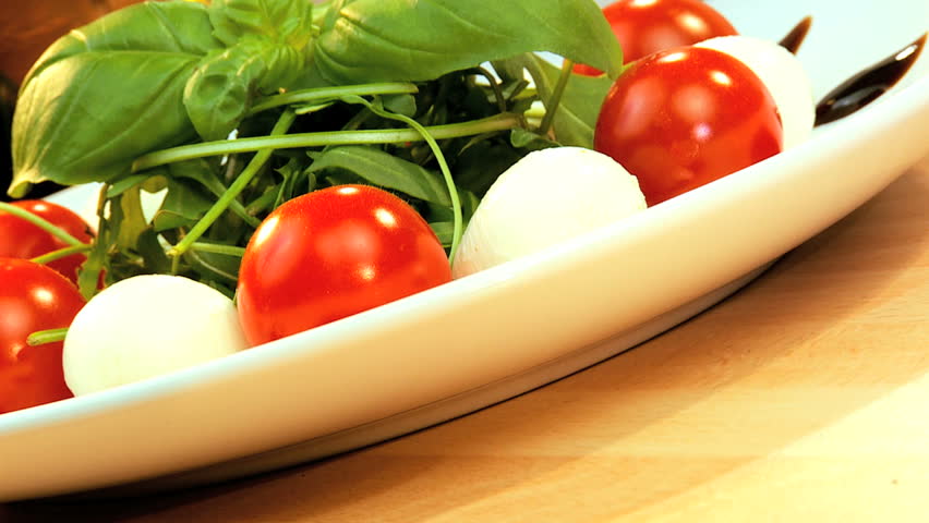 Tempting selection of fresh crisp salad, mozzarella cheese & oils making a healthy nutritious meal