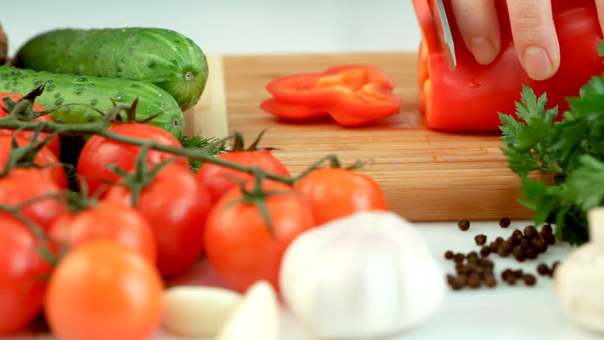 Female hands chopping red paprika (pepper)