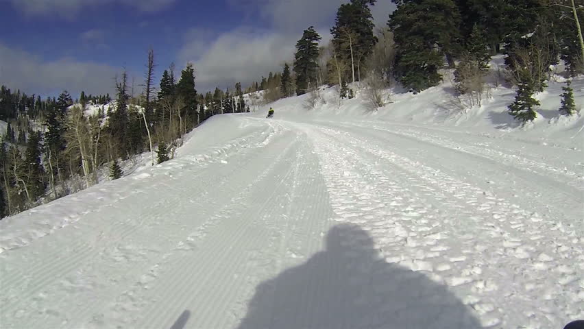 Snowmobile high mountain forest groomed road. Winter fun sport and recreation in the Rocky Mountains, Wasatch Range. High altitude snow excitement. Exploring the wilderness and remote areas of Utah.