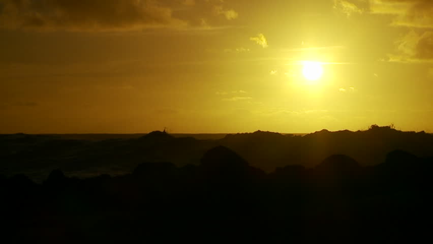 HAWAII, USA, 2012 The sunset behind waves as they crest and break in slow motion at sunset.