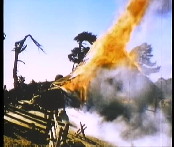 Wide shot of house in country engulfed in flames