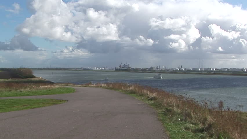 Heavy clouds across the mouth of the Rotterdam waterway with wind turbine in distance, The Netherlands 
