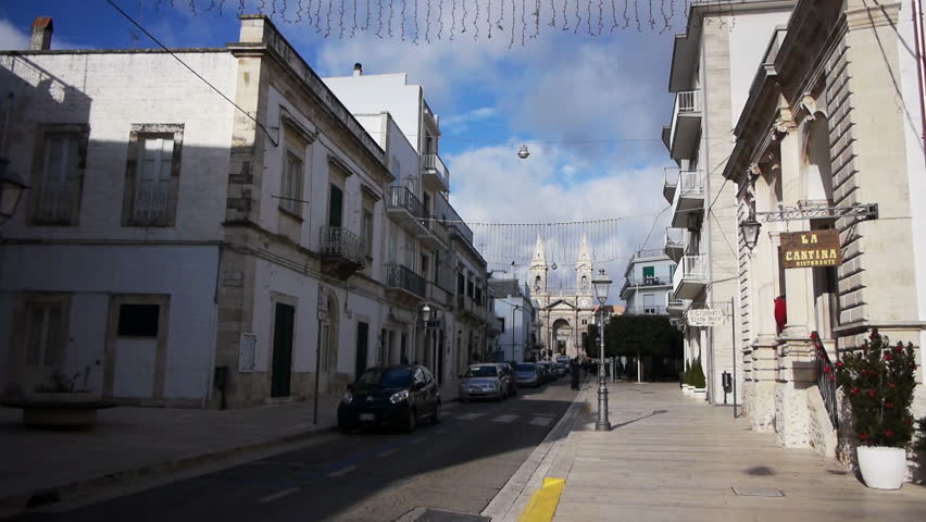 ALBEROBELLO, ITALY - December, 18: Street leading to Saint Cosma and Damiano Basilica on December, 18, 2013, Alberobello, Italy. Alberobello is UNESCO World Heritage Site highly visited all year round