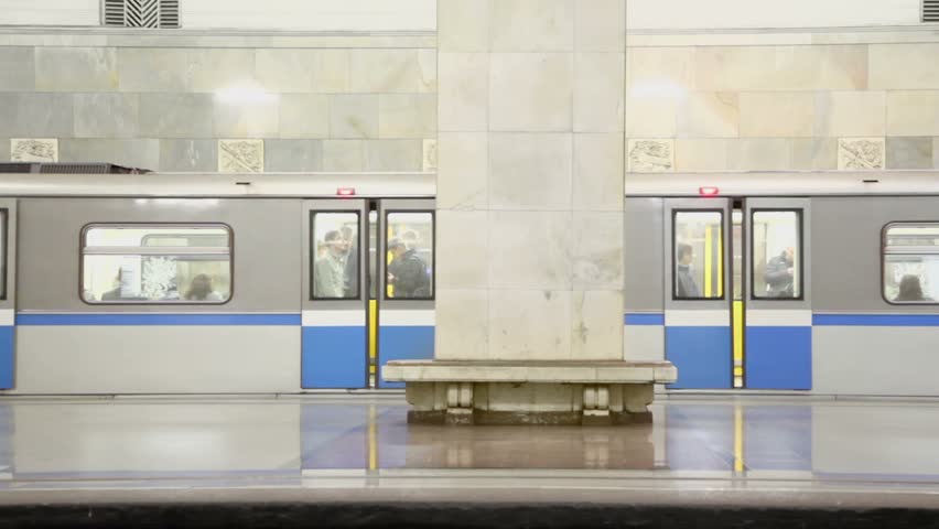 Doors close and train ride away from empty platform of metro station