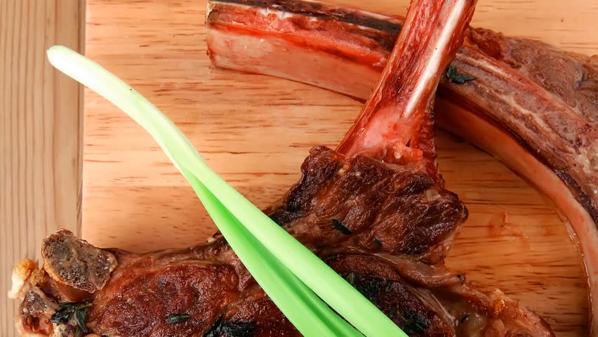meat savory : roasted beef ribs served with green chives over black table