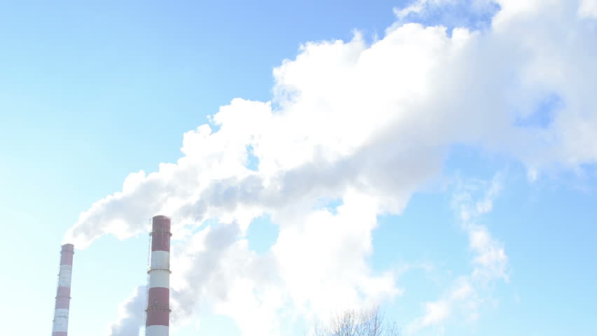 smoke fume vapour rise from industrial factory chimneys on background of blue sky. boiler-house heating all city houses in winter.