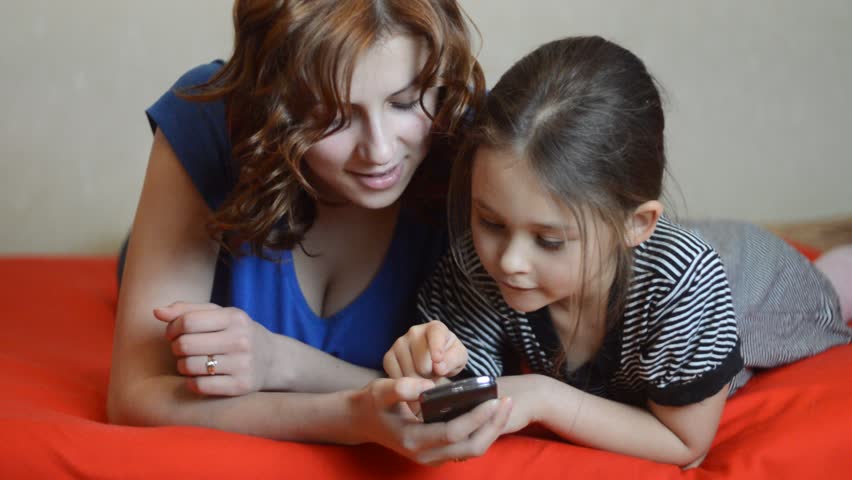 mother and daughter pressed a button on a mobile phone
