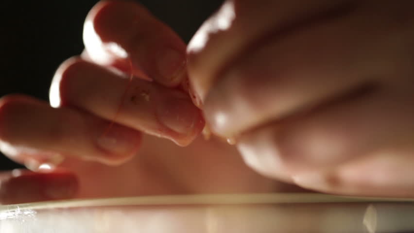 Women's hands are cleaning shrimp. Macro shot backlit.