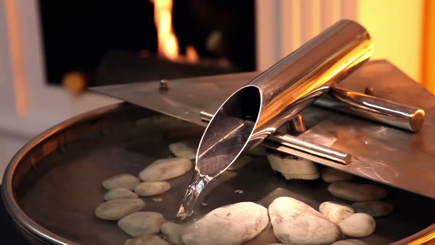 Contemporary indoors fountains. Fire in the fireplace in background