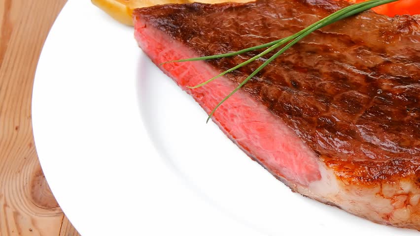 meat savory : grilled beef fillet mignon served on white plate with tomatoes and potatoes on wooden table