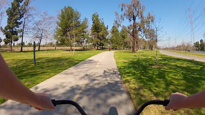 LONG BEACH, CA - February 23, 2013: The POV of someone riding a bicycle in El Dorado Regional Park circa 2013 in Long Beach.  Long Beach promotes bike riding and exercise.