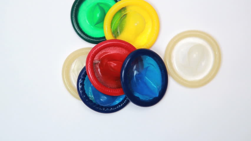 Condoms thrown on white surface spinning around