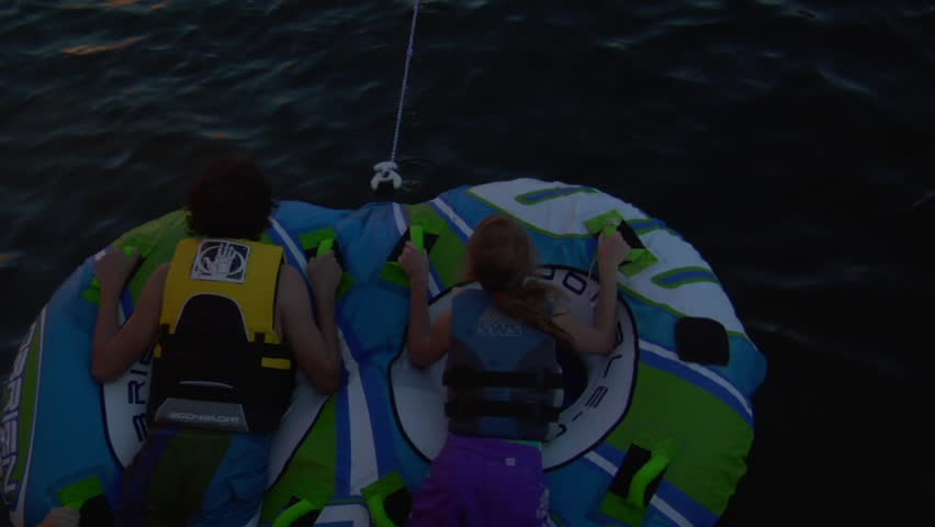 LAKE POWELL, UTAH - CIRCA 2010: kids on inter-tubes pulled by ski boat in the summertime