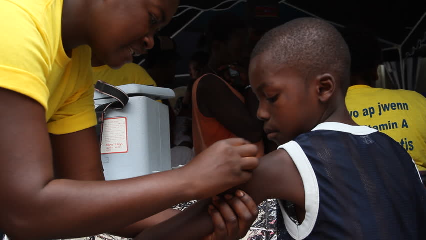 HAITI - CIRCA MAY 2012: young Haitian boy receives vaccination shot in Port-Au-Prince 