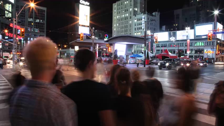 TORONTO - CIRCA 2012: Pedestrians and tourists cross through Yonge-Dundas Square. Since its completion in 2002, the square has established itself as a prominent landmark and prime tourist attraction.