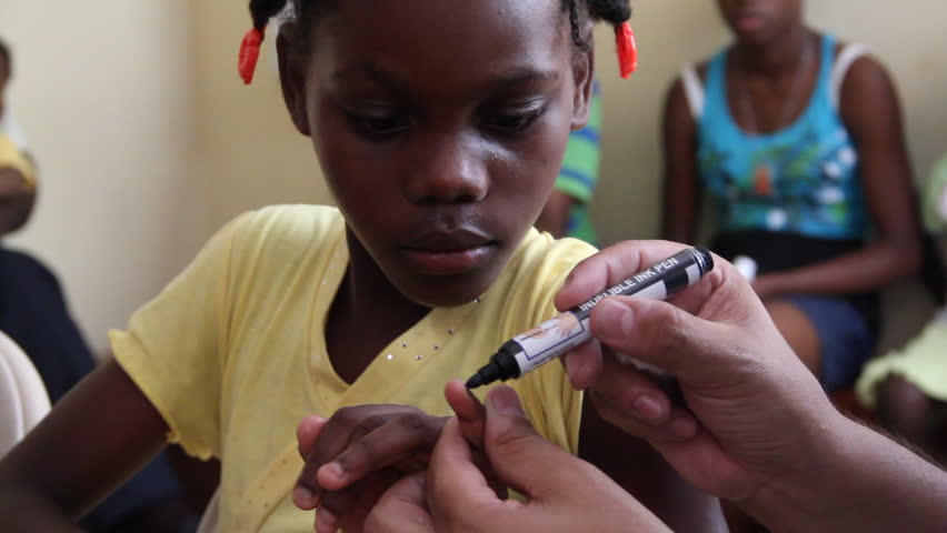 PORT AU PRINCE, HAITI  - CIRCA MAY 2012: Child receives fingernail mark after vaccination
