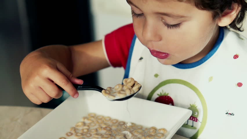 Little boy eating cornflakes with milk, slow motion shot at 240fps

