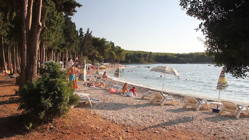 People on the beach, sunbathe and enjoy on vacation. Summertime at Adriatic Sea on the island Brac in Croatia