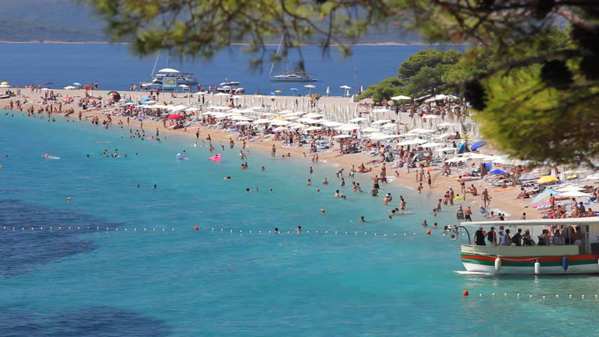People on the beach, sunbathing and swimming, enjoying on vacation. Famous beach in Bol on Island Brac in Croatia