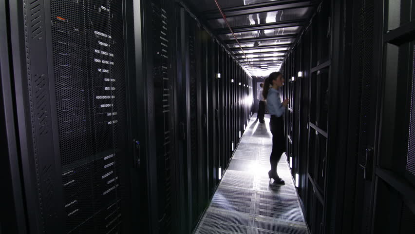 IT engineers carry out an inspection and maintenance procedure on servers in a dark data center. In time lapse