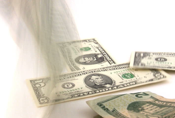 U.S. money falling on a white background.