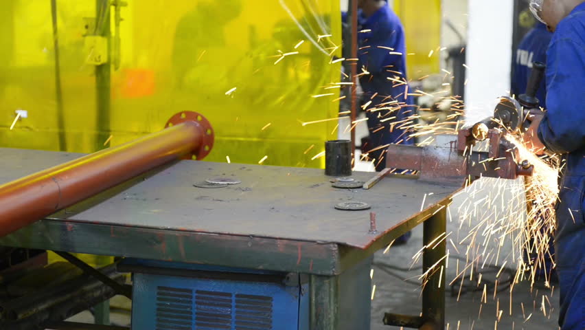 An industrial service repairmen labouring in workshop, selective focus, working on industry machine 