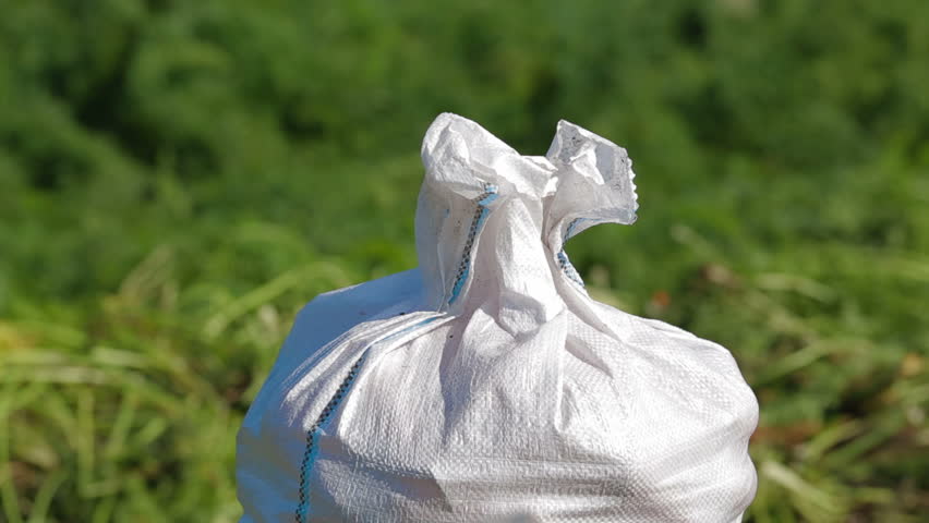 Sack is being tied by worker.