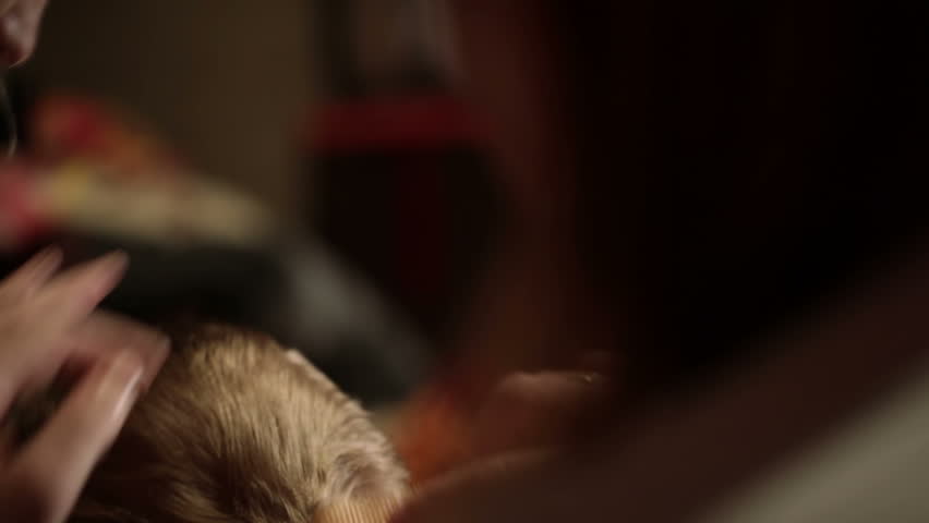 Mother cuts her child's hair. Close up. Shallow dof. Back light.