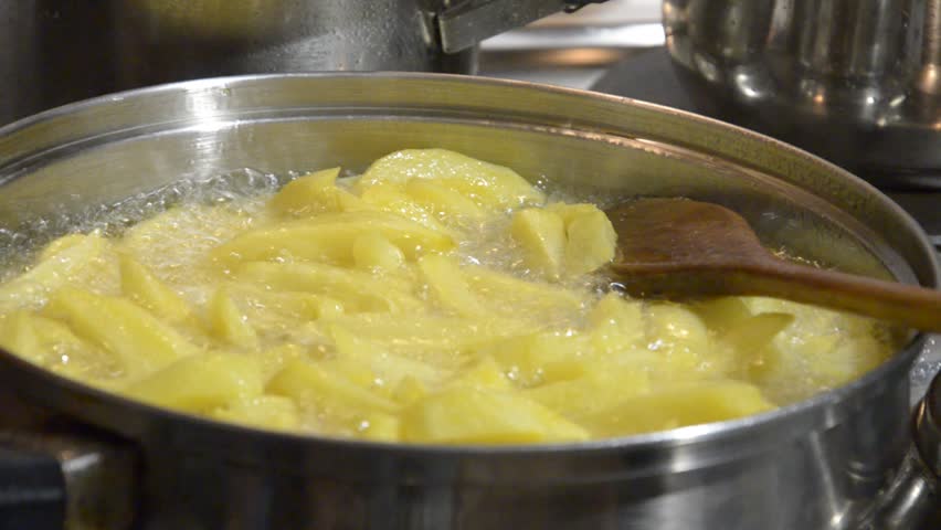 French Fries. Chips in a oily pan. Boiling in oil.