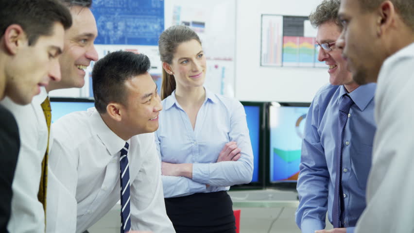 Diverse team of professionals, brainstorming in a business meeting under the watchful eye of their young female boss. She is evaluating her employees and takes pride in their expertise. 