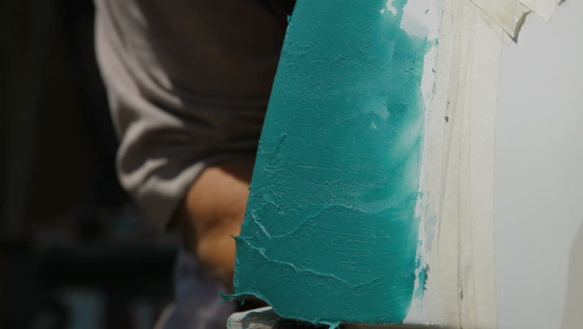 Smearing putty on damaged car surface layer by layer, close-up.