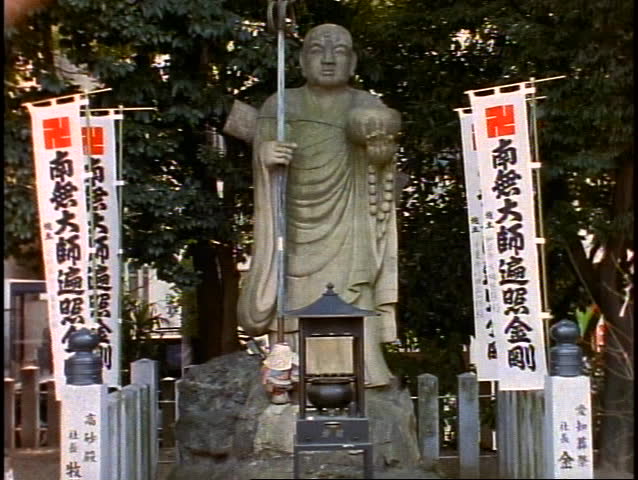 Japanese Shrine, figure standing, banners around, tilt up, medium shot