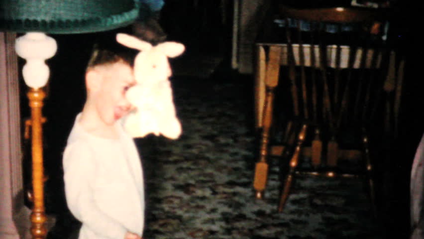 JOHNSTOWN, NEW YORK, 1957: A cute little boy freaks out because he just found a new yellow stuffed rabbit during his Easter egg hunt in 1957.
