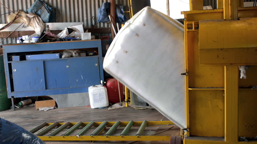 WOODANILLING, AUSTRALIA - November 21, 2012: A shedhand removing a bale of wool from a wool compressor, during shearing on an Australian farm, on November 21, 2013.