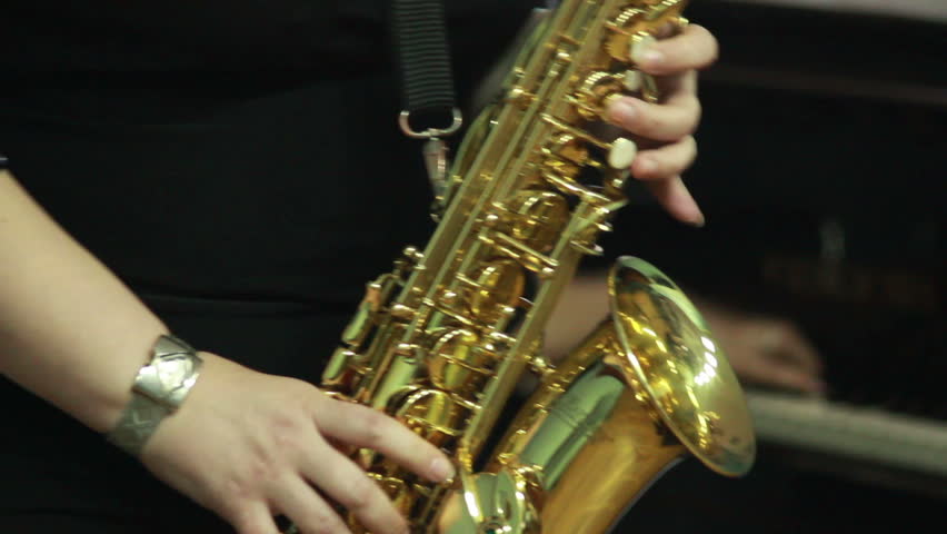 woman's hands playing saxophone
