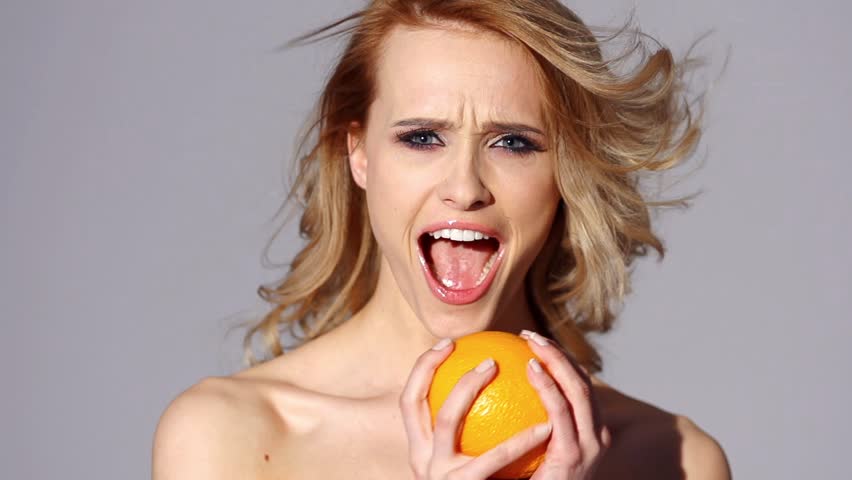 Hilarious Girl Holding Orange Fruit on Slow Motion Video

