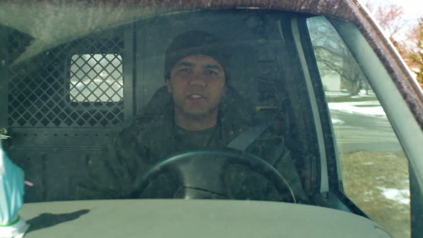 Man grooves to the music playing in his dirty van as he drives along. Mid shot.