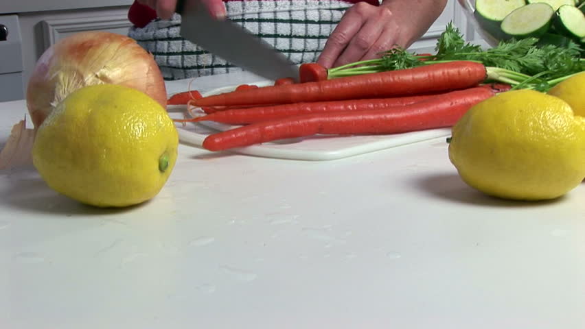 A mature woman cooking a healthy meal in her kitchen.